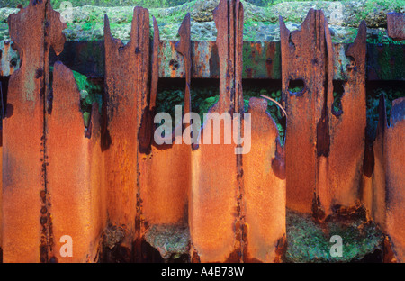 Dettaglio di ferro per la difesa del mare in modo arrugginiti e rotto da essere inutile con calcestruzzo eroso seawall dietro Foto Stock