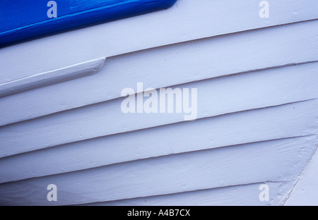 Dettaglio del lato della prua della barca di legno che mostra ben curato per la sovrapposizione di travi in legno dipinto di bianco con dettagli blu Foto Stock