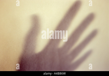 Close up di ombra sul muro di crema di mano gesticulating o enfatizzare o implorando o memoria o scongiurare Foto Stock