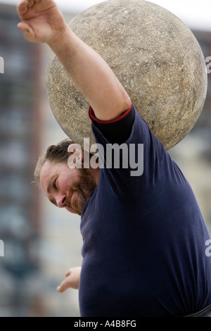 Harrijasotzaileak (pietra sollevamento) concorrente portando la sfera di granito su spalle, basco uomo forte giochi, Bilbao, Paese Basco Foto Stock