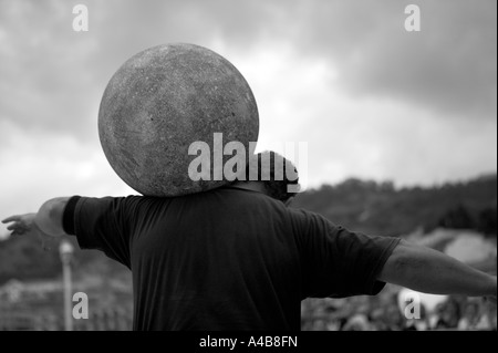 Harrijasotzaileak (pietra sollevamento) concorrente portando la sfera di granito su spalle, basco uomo forte giochi, Bilbao, Paese Basco, Foto Stock