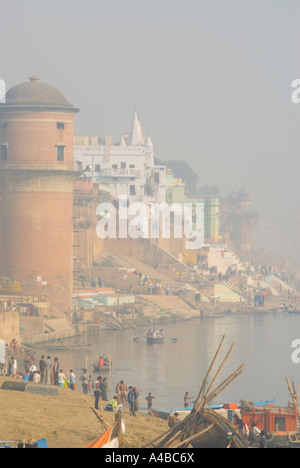 Immagine di stock di Acqua torre lungo i ghats del Gange a Varanasi India con barche e pellegrini Foto Stock