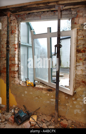 Puntelli ACROW tenendo un soffitto e travetti al fine di rimuovere una vecchia finestra con architravi inadeguata Foto Stock