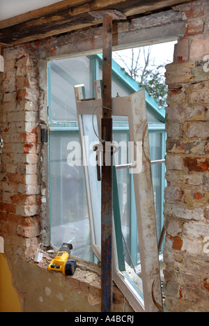 Puntelli ACROW tenendo un soffitto e travetti al fine di rimuovere una vecchia finestra con architravi inadeguata Foto Stock