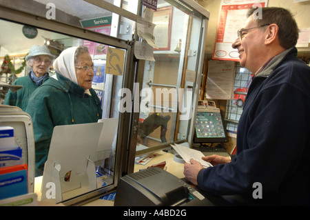 I PENSIONATI coda presso un ufficio postale e negozio di paese a MONKTON FARLEIGH WILTSHIRE REGNO UNITO CHE È SOTTO LA MINACCIA DI CHIUSURA Foto Stock