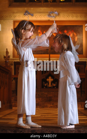 Angeli mettendo sul loro aloni PRIMA DI UNA SCUOLA PRIMARIA NATIVITÀ GIOCARE IN UNA CHIESA SOMERSET REGNO UNITO Foto Stock