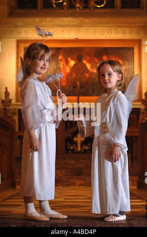 Angeli mettendo sul loro aloni PRIMA DI UNA SCUOLA PRIMARIA NATIVITÀ GIOCARE IN UNA CHIESA SOMERSET REGNO UNITO Foto Stock