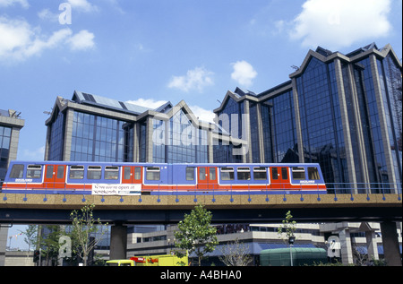 La Docklands Light Railway in esecuzione su OVERGROUND pista al fianco di edifici commerciali di Londra, Inghilterra 1999 Foto Stock
