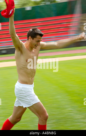 Fussball, Spieler laeuft nach dem Sieg durch das Stadion, soccer player in esecuzione attraverso il soccer hall af Foto Stock