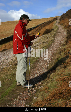 Walker utilizzando un GPS palmare sistema di navigazione su una escursione nel Pentland Hills Scozia Scotland Foto Stock