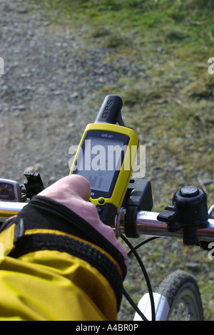 Ciclista utilizzando un palmare GPS Navigation system collegato al manubrio in Pentland Hills Scozia Scotland Foto Stock