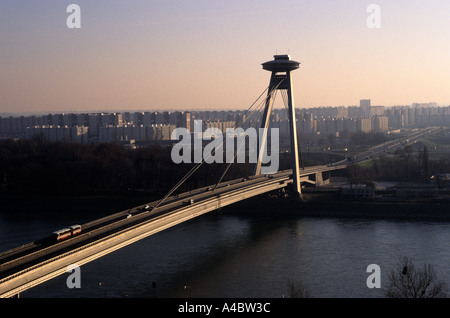 Bratislava, Slovacchia; nuovo ponte sul Danubio con stile sovietico blocchi di appartamenti in distanza. Foto Stock