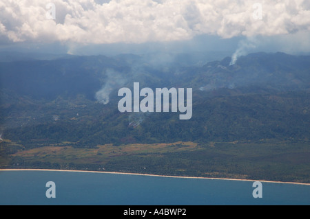 Riprese aeree della costa a sud di Maroantsetra mostra di foreste pluviali vengono bruciate per rendere i campi di riso Foto Stock