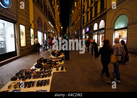 Venditori ambulanti di vendita falsi borsette nel centro di Firenze di notte Italia EU Europe Firenze Foto Stock