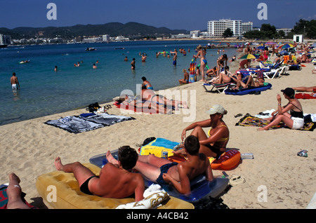 I turisti a prendere il sole sulla spiaggia di San Antonio, Ibiza, Spagna Foto Stock