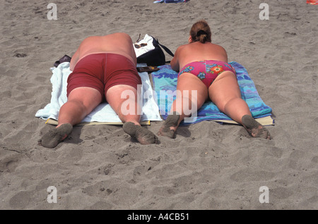 I turisti britannici prendono il sole sulla spiaggia di Tenerife, Spagna Foto Stock