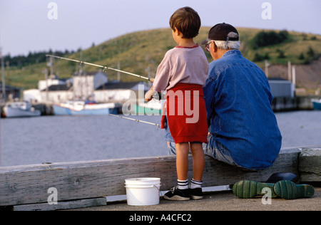 Un nipote e nonno pesca al largo di un pontile. Foto Stock