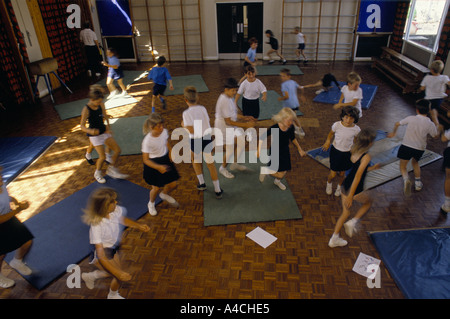 Gli alunni in esecuzione geografica nella palestra di classe ad una scuola primaria6 Foto Stock