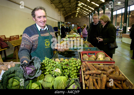 Farmers Market trader vendita organici la frutta e la verdura Brecon Galles. Foto Stock