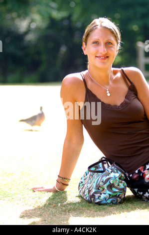 Royalty free fotografia del British College studente o lavoratore di ufficio rilassante in London Park Regno Unito con la tintarella e protezione per la pelle. Foto Stock