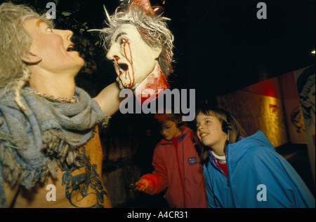 I bambini guardando il display del druido rituali, uomo con una testa di spurgo. Le Bianche scogliere di esperienza, Dover, Inghilterra, marzo 1994 Foto Stock