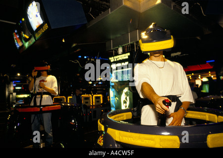 Una persona che gioca un gioco di realtà virtuale indossa una visiera speciale per accedere al mondo virtuale e sparare a delle immagini del computer. Foto Stock