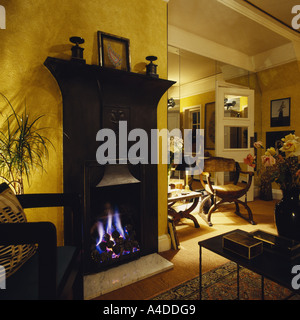 Illumina di un caminetto a gas tradizionali in ghisa nera camino in moderno degli anni ottanta soggiorno Foto Stock