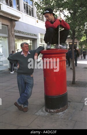 Un anti-globalizzazione protester sorge sulla cima di una lettera-box in Oxford Street, Londra centrale, giorno di maggio Londra, Foto Stock