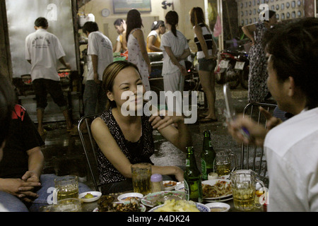 Folle a una pavimentazione serale ristorante, a Saigon, Vietnam Foto Stock