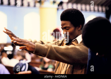 Un uomo che prega nella chiesa pentecostale di Brixton, London, Regno Unito Foto Stock