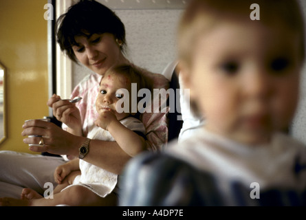 Un childminder alimenta un bimbo. La Creche des Halles di Parigi. Francia Foto Stock