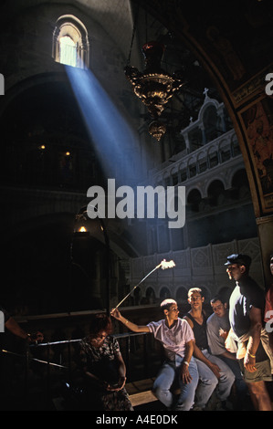 Albero della luce che risplende sui turisti e guida in [Chiesa del Santo Sepolcro di Gerusalemme] Israele Foto Stock