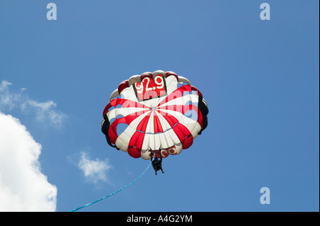 Il parasailing alta contro il cielo blu e nuvole Foto Stock