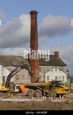 Ex stabilimento industriale sito di costruzione essendo ristrutturato con gru di scavo e camion Glastonbury Somerset 2007 Foto Stock