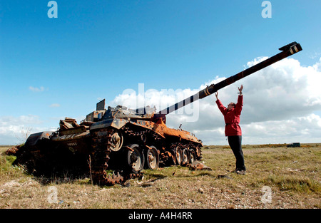 Un storico militare sulla Piana di Salisbury con la carcassa di un capotribù serbatoio ora utilizzato per il tiro al bersaglio. Foto Stock