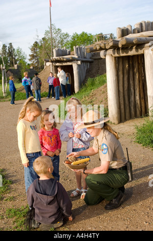 Ranger del Parco che mostra i ragazzi artefatti a su una inclinazione villaggio Mandan in Fort Abraham Lincoln parco dello Stato del North Dakota Foto Stock