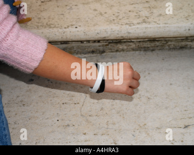 Adolescente che indossa la carità banda avorio ebano contro il razzismo bianco nero Foto Stock