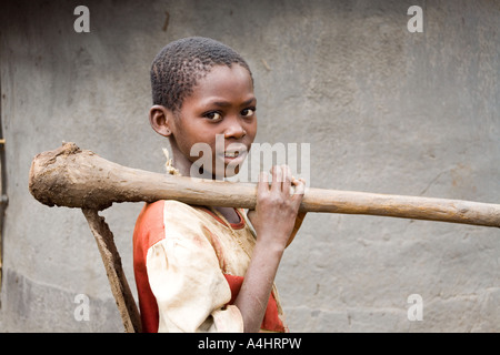 Una giovane ragazza che porta una vanga pesante o Khasu (HOE) nel villaggio di Mambala Africa Malawi Foto Stock