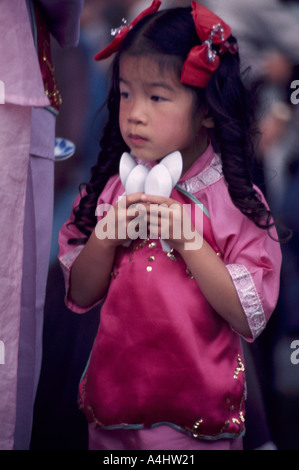 Una giovane ragazza cinese di cucchiai di contenimento al nuovo anno sfilano e Festival in Chinatown, Vancouver, BC, British Columbia, Canada Foto Stock