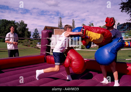 Due uomini boxe con oversize guantoni da pugilato in un pneumatico gonfio pugilato ring in British Columbia Canada Foto Stock
