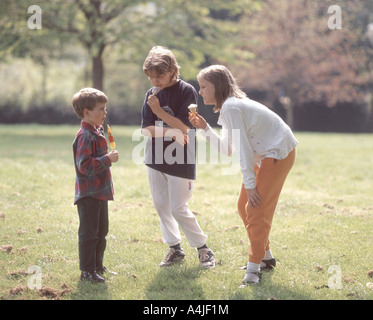 I bambini a mangiare gelati in giardini, Hampstead Heath, London, England, Regno Unito Foto Stock