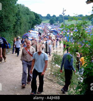 I frequentatori del festival a piedi lungo il sentiero vicino al campeggio al festival di Glastonbury Somerset England Regno Unito KATHY DEWITT Foto Stock