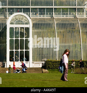 La famiglia gioca su erba al di fuori della Grande Casa delle Palme Kew Garden Foto Stock