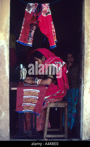 Donna locale a lavorare presso la sua macchina da cucire per creare raffinatezze all annuale Puskar camel fair in Rajasthan s grande deserto di Thar Foto Stock