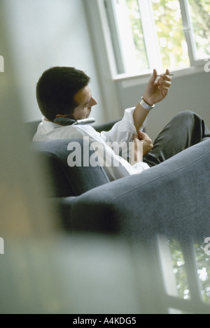 L'uomo parlando al cellulare e abbottonatura manicotti Foto Stock