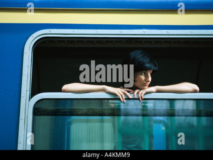 Donna sul treno, guardando fuori della finestra aperta Foto Stock