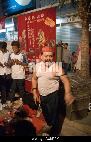 Un indonesiano di olio di serpente venditore attira una folla di interessati agli scommettitori a Johor Bahru Malesia Foto Stock