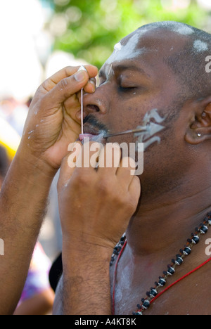 Gli indiani malesi celebrano Thaipusam a Georgetown Penang Island, Malesia. Un devoto ha il volto e la lingua trafugati Foto Stock