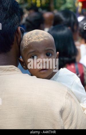 Bambino con la testa rasata. La rasatura della testa è un modo tradizionale degli indiani malesi per celebrare il Thaipusam a Georgetown Penang. Foto Stock