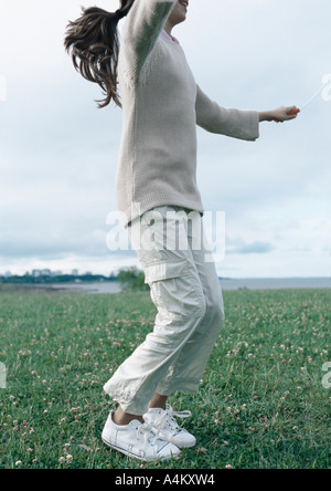 Ragazza salto con la corda di erba Foto Stock